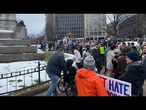 Protesters, counter-protesters walk with signs at the People's March