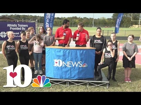 Heritage Middle School Color Guard marches with the high school band