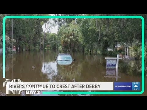 In neighborhoods near the Alafia River, residents use canoes to navigate major flooding