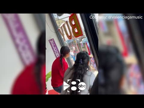 Witnesses watch as police execute a search on an "illicit massage business"