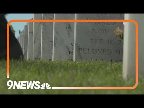Volunteers place flags on graves at Fort Logan Cemetery for Memorial Day