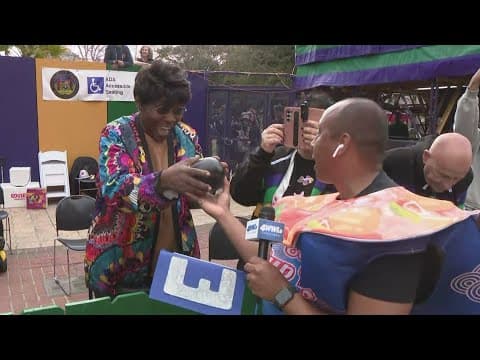 Parade goer gets cherished Zulu coconut from WWL's Ricardo LeCompte