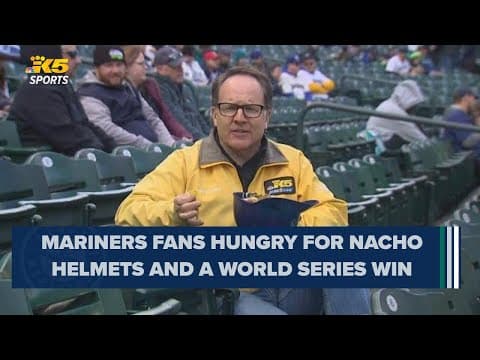 KING 5's Drew Mikkelsen enjoys a nacho helmet while reporting on Mariners opening day