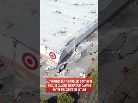 A Target store is breaking apart as the ground below the foundation starts sliding down a hill.