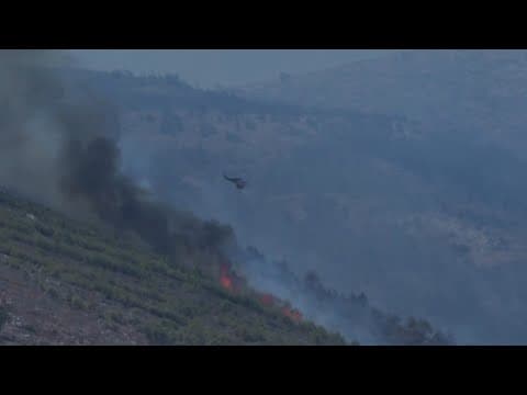 Smoke plumes darken sky as firefighters battle wildfire on hills northeast of Athens