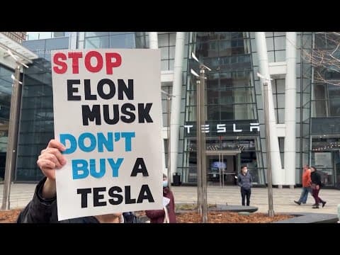 Demonstrators gather outside a Tesla showroom in Boston to protest against Trump and Musk