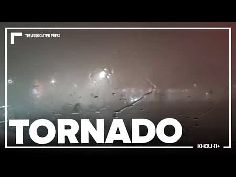 Father and son watch from the car as a tornado passes by