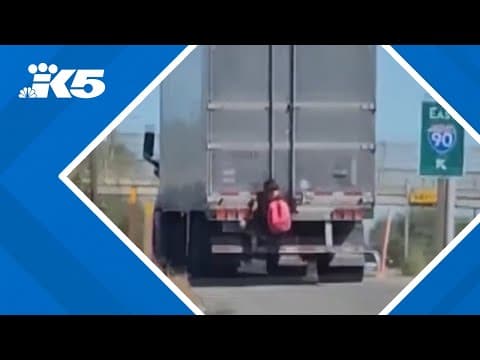 Video shows man hanging from back of semi-truck on I-90 in Spokane