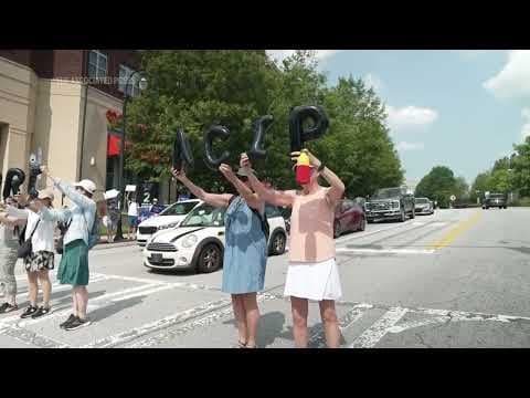 People rally outside of CDC headquarters during vaccine meeting