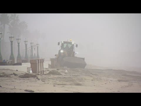 City crews clean up boardwalk after big waves crash over beach wall in Mission Beach