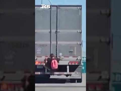 Video shows man hanging from back of semi-truck on I-90 in Spokane
