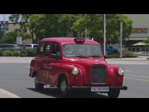 Soccer fans ride to the match at Snapdragon in British-themed red taxis