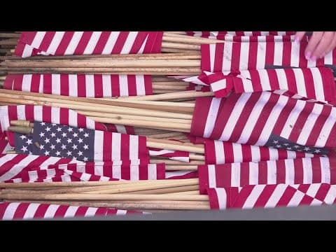 People place flags on graves for Memorial Day