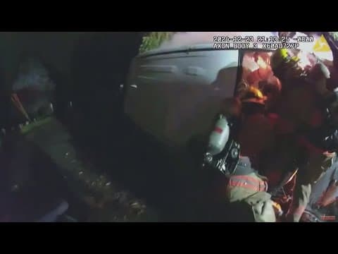 Rescuers save a women from her car after a fiery crash