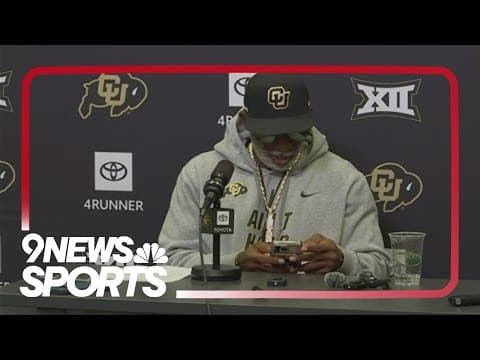 Deion Sanders checks his phone's weather app to see if there will be rain in Baylor game