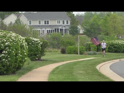 A veteran runs while holding a flag, inspiring his neighborhood