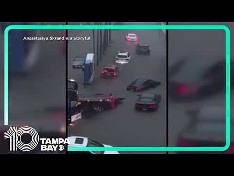 Tow truck attempts to get car out of Miami floodwaters