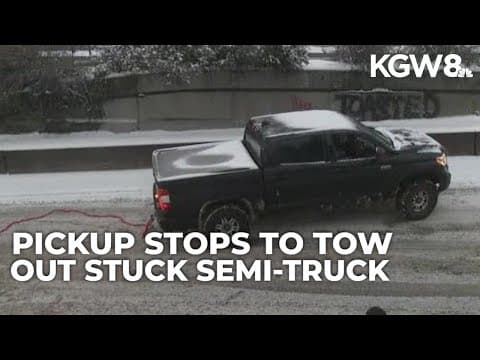Pickup truck helps tow out stuck semi-truck in snow on I-405 in Portland