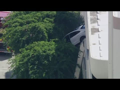 SUV dangles off Florida parking garage