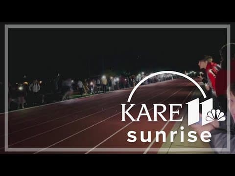 Runners illuminate the night after lights go out during track meet