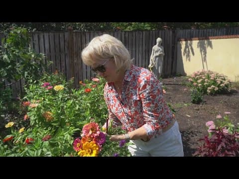 A woman exchanges flowers for donations to her local food bank