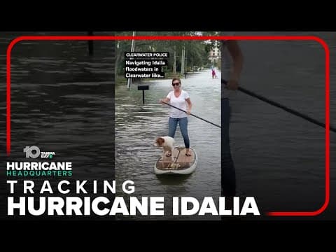 Woman paddleboards with dog on Idalia floodwaters