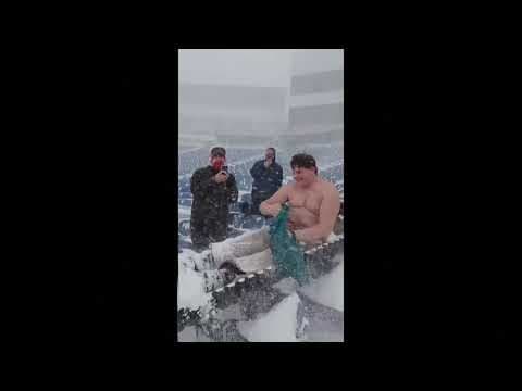 Fan slides down snow-covered stairs inside the Buffalo Bills NFL stadium