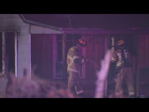Fire crews work to put out a fire in an abandoned home