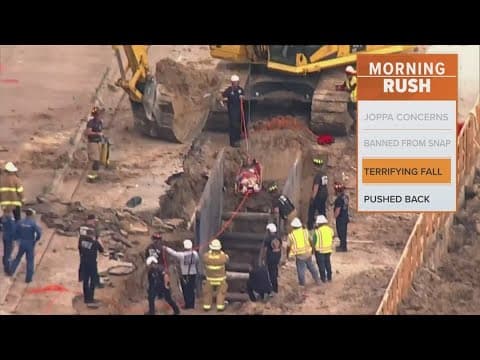 Firefighters rescue a construction worker who fell into a large trench