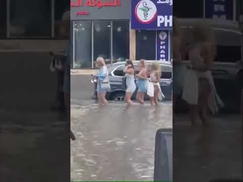 People wade through Dubai floodwaters during historic rainfall
