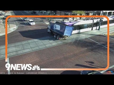 Light rail runs red light and into trash truck