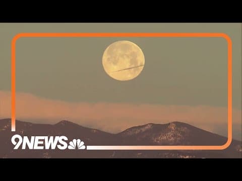 Dazzling shot of full wolf moon setting behind the Colorado Rocky Mountains