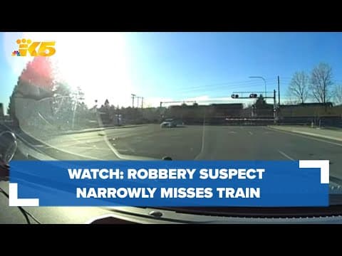 Dashcam video shows fleeing robbery suspect narrowly misses train